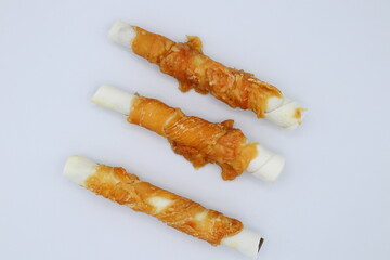 Chew stick dogs. Wrapped in meat. Candy or treat for pets. Close up and isolated.