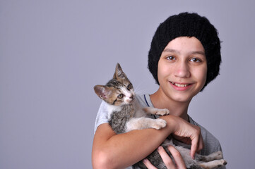 Menino com gatinho doméstico fofo em retrato de estúdio, adoção de animais conciente , amor aos...