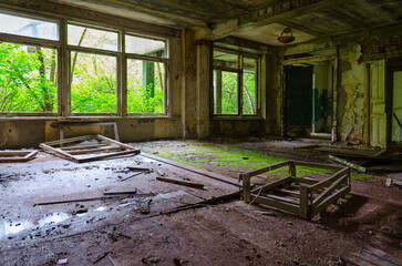Fototapeta na wymiar Devastation in premises of abandoned school in resettled village of Pogonnoye in exclusion zone of Chernobyl nuclear power plant, Belarus