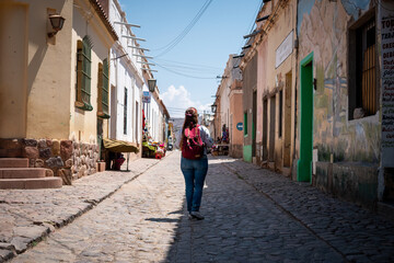 Mujer caminando por las calles de la ciudad de Humahuaca - obrazy, fototapety, plakaty