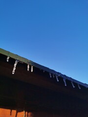 Icicles hang from the roof of the house.