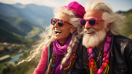 Happy, laughing elderly couple, dressed in  psychedelic clothes in the style of 1970's. The concept of Healthy ageing - obrazy, fototapety, plakaty