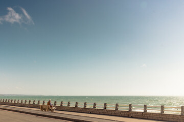 homme assis sur un banc face à la mer