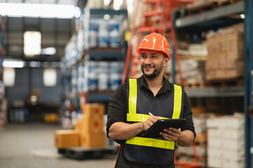 Professional manager man employee smile using tablet check stock working at warehouse. Worker wearing high visibility clothing and a hard hat, helmet and checking and count up goods boxes delivery.