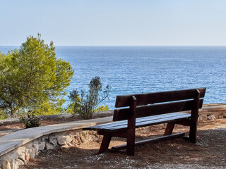 Wooden bench looking to the Mediterranean sea in Benissa Ecological Walk, Paseo Ecologico in...