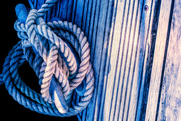 close up of yacht or boat mooring rope tied around cleat in harbour