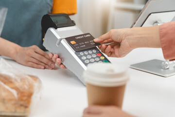 Cashless payment in shopping concept, Close-up hands using credit card pay at cafe.