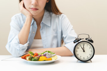 Intermittent fasting concept, Close-up on clock and people feeling hungry waiting time to eat during intermittent fasting diet session