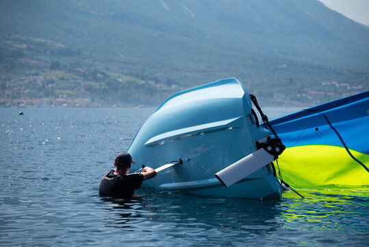 The moment of a capsizing incident during a sailing race, illustrating the technical dynamics of a boat losing its stability. the boat's heeling, loss of equilibrium, and the consequential event