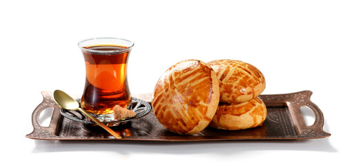 Traditional turkish breakfast buns ( pogaca ) served with black turkish tea. isolated on white background
