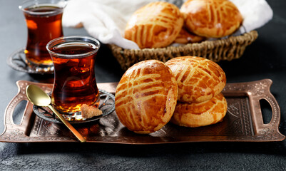 Traditional turkish breakfast buns ( pogaca ) served with black turkish tea.