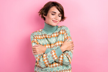 Portrait of attractive young girl wearing ornament stylish sweater hugs herself close eyes...