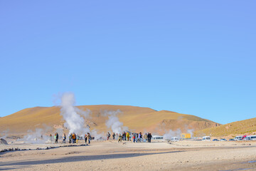 Turistas circulando no Gêiser Tatio no deserto do Atacama durante o começo do dia. Nascer do sol. 