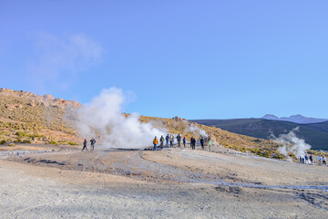 Turistas circulando no Gêiser Tatio no deserto do Atacama durante o começo do dia. Nascer do sol. 