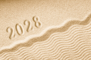 Fototapeta na wymiar Imprints of numbers 2028 happy new year on a golden sand waves
