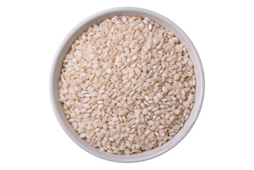 White uncooked rice in a round ceramic bowl on a dark concrete background