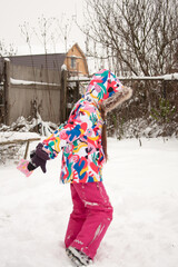 child playing with snow in winter