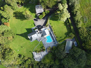 Aerial view of a large rural mansion with a swimming pool in the Anglesey countryside, UK
