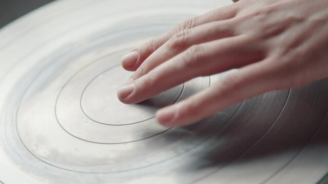The ceramist stops the potter's wheel with a fingers. Tool for the potter in the creative workshop.