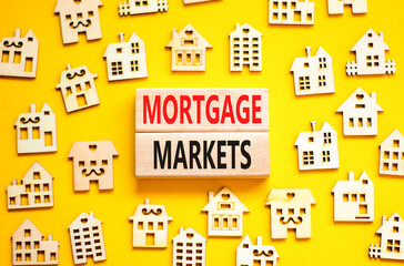 Mortgage markets symbol. Concept words Mortgage markets on beautiful wooden blocks. Beautiful yellow table yellow background. House model. Business mortgage markets concept. Copy space.