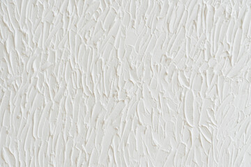 Close-up of a textured white wall with elements of abstract concrete surface creating a rough and unique backdrop, showcasing a blend of beige and brown tones in a captivating design