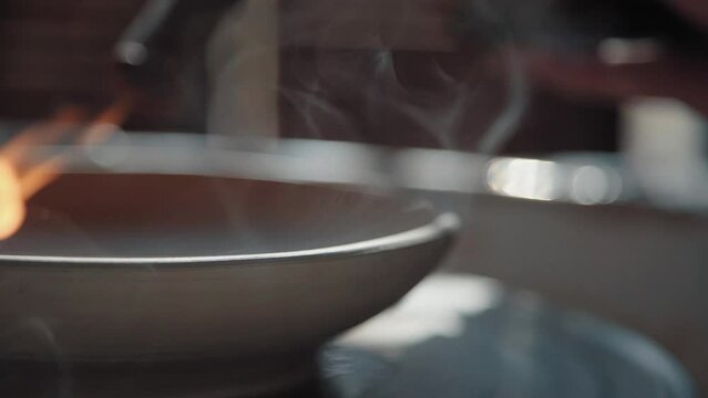 Clay plate on the potter's wheel, the process of creation. Female hand makes the form, close-up, shot from the side.