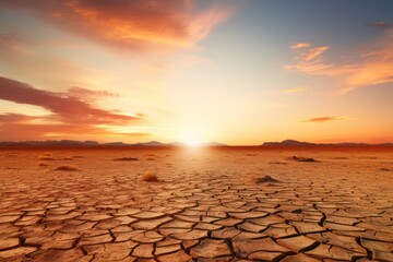 Drought climate and Global warming concept. Cracked earth, arid landscape, at sunset 