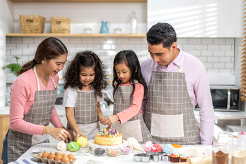 Obraz na płótnie Canvas Portrait of enjoy happy love asian family father and mother with little asian girl daughter child play and having fun cooking food together with baking cookie and cake ingredient in kitchen