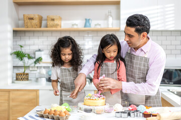 Portrait of enjoy happy love asian family father with little asian girl daughter child play and having fun cooking food together with baking cookie and cake ingredient in kitchen