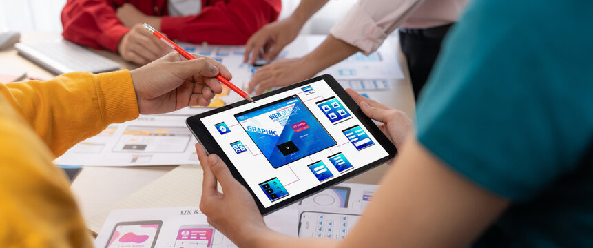 Panorama banner of startup UX developer or company employee design user interface or UI prototype for mobile application or website software with software display on tablet screen in office. Synergic