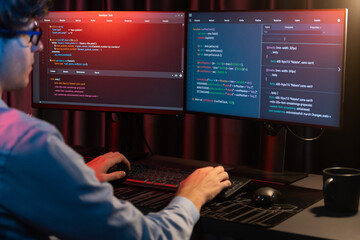 Working IT developer concentrating online software development information on surrounded by coding...