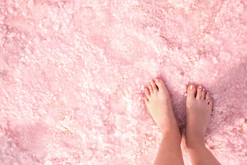 Pink lake. Girl's feet on water with pink salt. A unique rare natural phenomenon. Salt Lake. - obrazy, fototapety, plakaty