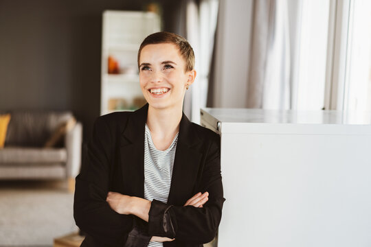 Confident Young Woman with Short Hair Laughing Joyfully in Modern Office Environment
