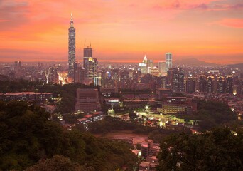 Obraz premium Aerial panorama of Taipei City with Taipei 101 Tower among skyscrapers in downtown area at dusk ~ A romantic evening in Taipei, the capital city of Taiwan, with beautiful rosy afterglow in the sky