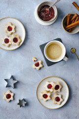 Linzer cookies on plates and coffee cup, cookie cutters around