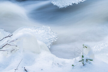 Fototapeta na wymiar Winter's magic by natural stream in winter