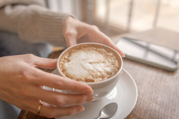 Young woman holding a cup of coffee in her hands