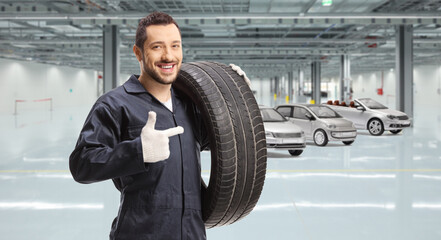 Fototapeta na wymiar Worker holding a tire at a car manufacturing plant