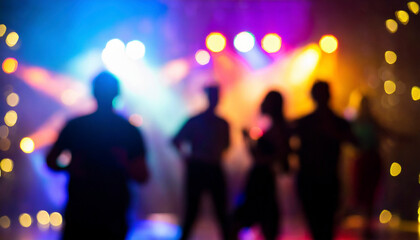 blurred background of people dancing at a music festival on stage.