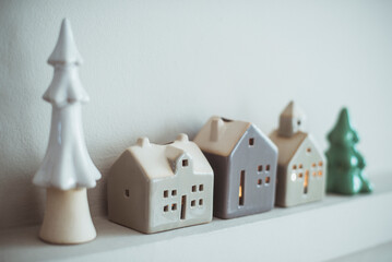 Ceramic Christmas tree and House tea light holders on a mantelpiece