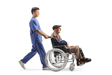 Male health care worker pushing an elderly injured man in a wheelchair