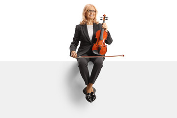 Woman with a violin sitting on a blank panel © Ljupco Smokovski