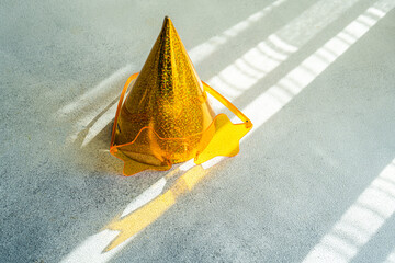 Close-up of a yellow party hat on a table with novelty star shaped plastic glasses on a table