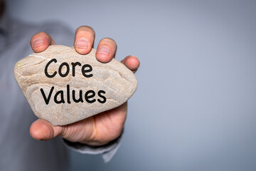 Our core values symbol,  Businessman holds in his hand a stone with the principles of his company...