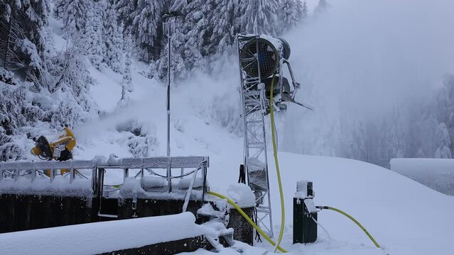 Verschneite Landschaft und Schneekanonen im Winter mit Drohne