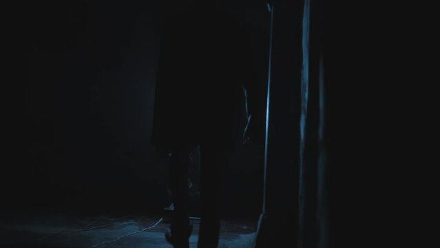 Creative nighttime footage of a gangster in simple clothing climbing upstairs after completing a deal at late hours, HD cinema-style high-quality stock footage. Backside shot.
