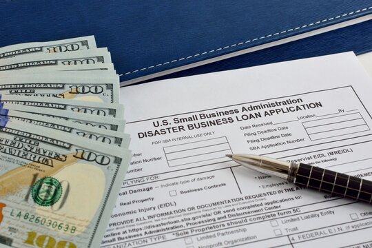 Small business Administration Disaster Business loan application form on the office table with pen and dollar bills
