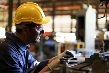 Professional white ethnicity mechanical engineer inspecting and measuring the metal gear, engineer or repair man examine and fix machine in factory.