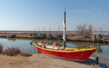 Fototapeta premium Barque et filets de pêche aux cabanes de Mauguio au milieu d'un étang en Camargue, Sud de la France.