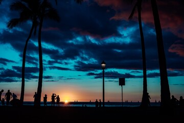 As the warm afterglow of the hawaiian sunset silhouettes a group of travelers on the sandy beach, their hearts are filled with the joy of exploring kauai and oahu, surrounded by towering palm trees a